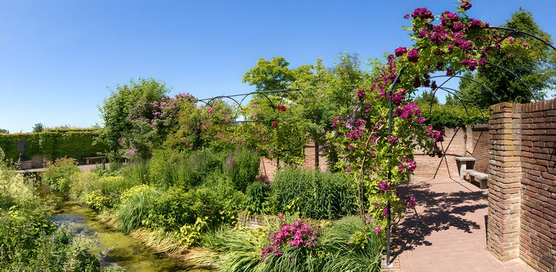 Sfeervolle bloementuin met waterloop