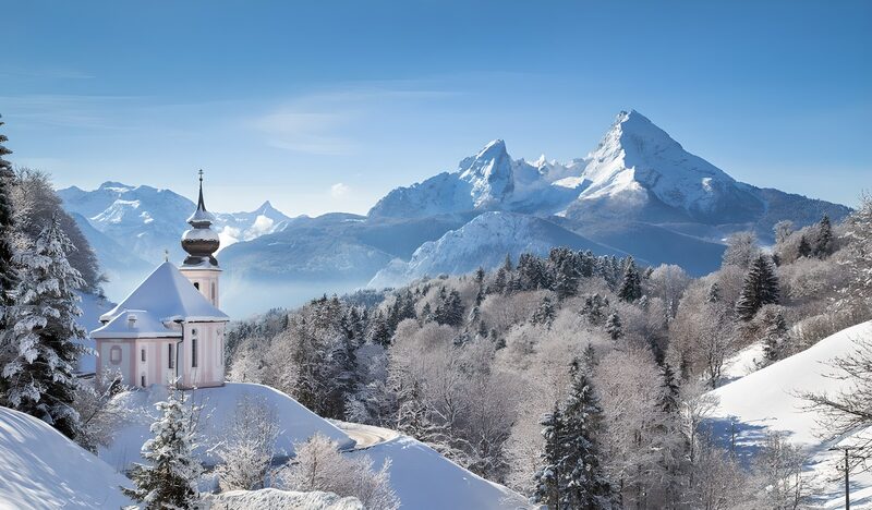 Sneeuwlandschap met kerk en bergen