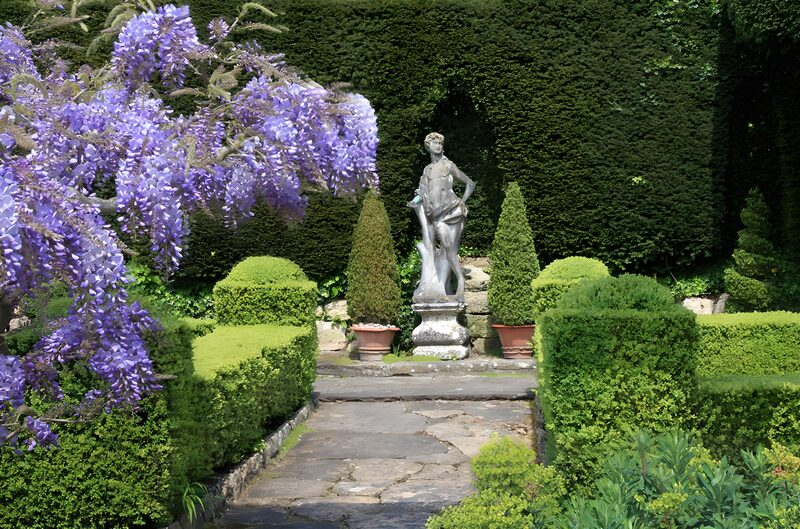 Prachtige tuin met beeld en bloemen