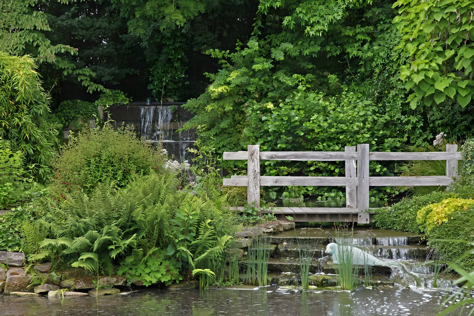 Rustgevende tuin met houten brug en waterval