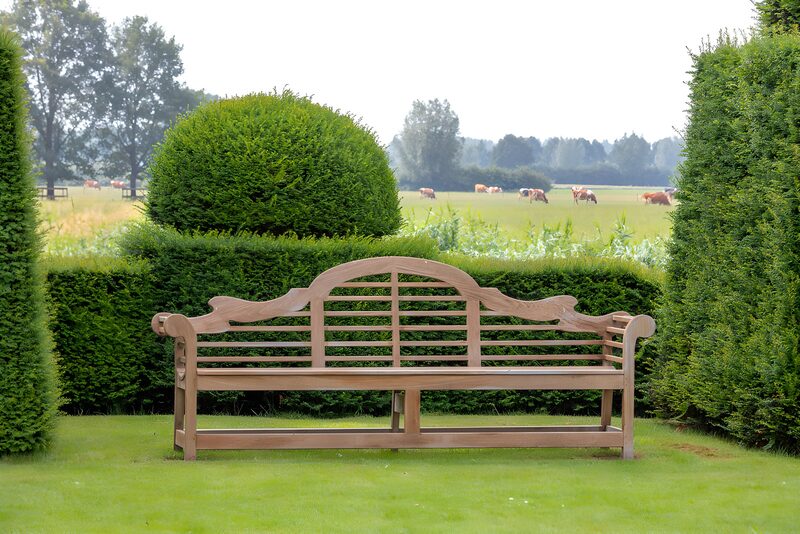 Rustieke bank in groene tuin