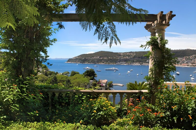 Uitzicht vanuit villa tuin op luxe jachtboten