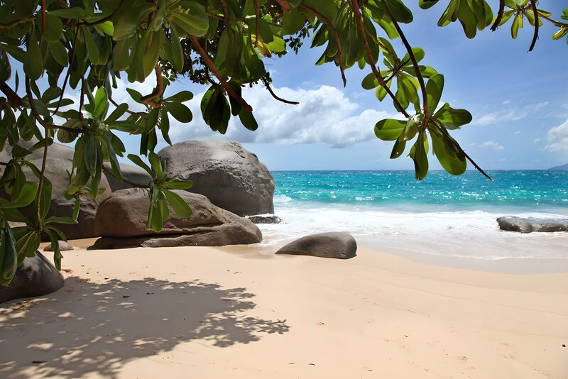 Tropisch strand met rotsen en blauw water